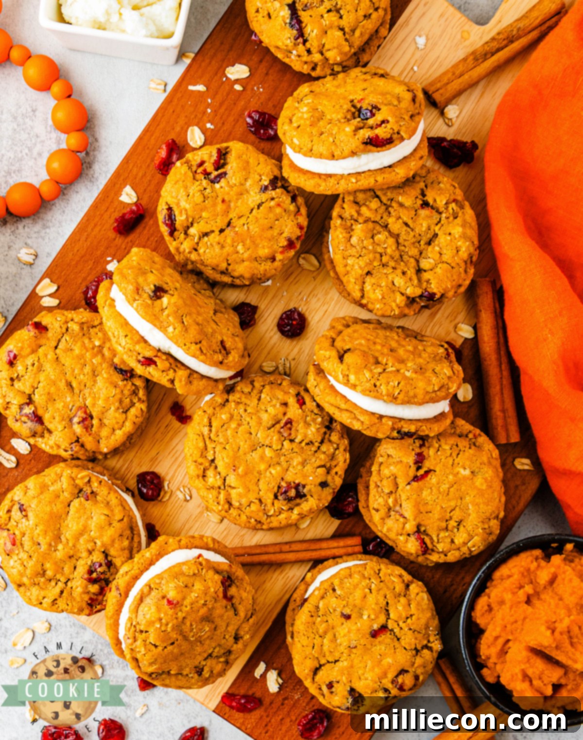 Spiced Pumpkin Cranberry Oatmeal Sandwich Cookies 8 Pumpkin oatmeal sandwich cookies showing soft centers and creamy frosting between layers.
