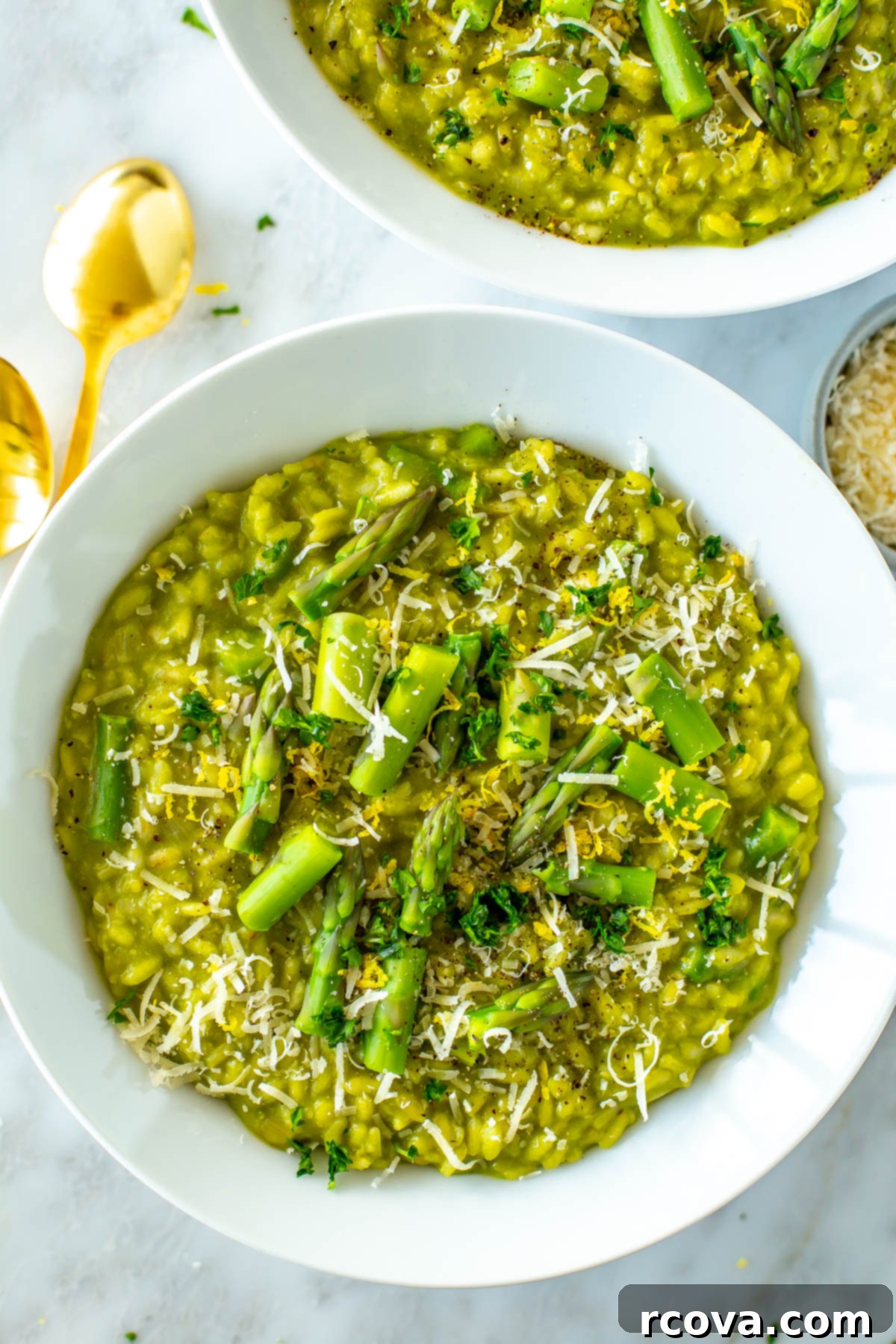 Velvety Asparagus Risotto 10 A close-up of a rustic bowl of creamy asparagus risotto, garnished with fresh herbs and a wedge of lemon.