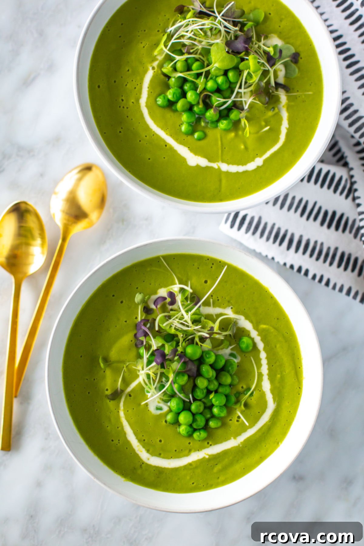 Garden Fresh Spring Pea Soup 2 Two bowls of vibrant green spring pea soup garnished with microgreens, with bread slices on the side, ready to be served.