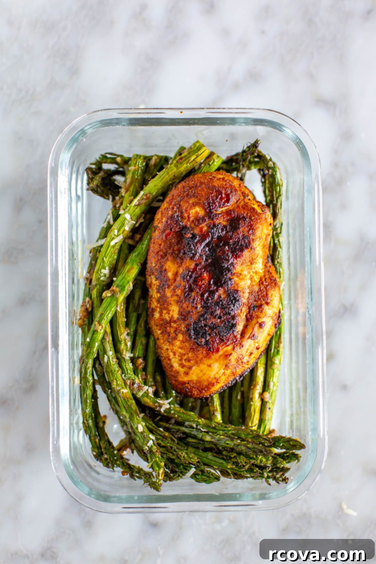Crispy Air Fryer Asparagus 9 A meal prep container showing crispy air fryer asparagus next to a perfectly cooked chicken breast, ideal for healthy eating.