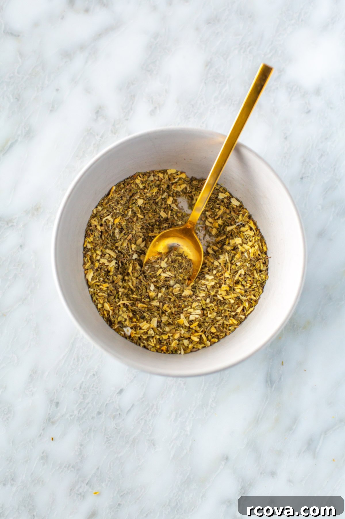 Effortless Greek Spice Blend 6 Homemade Greek seasoning mixed in a bowl with a spoon, showing its texture