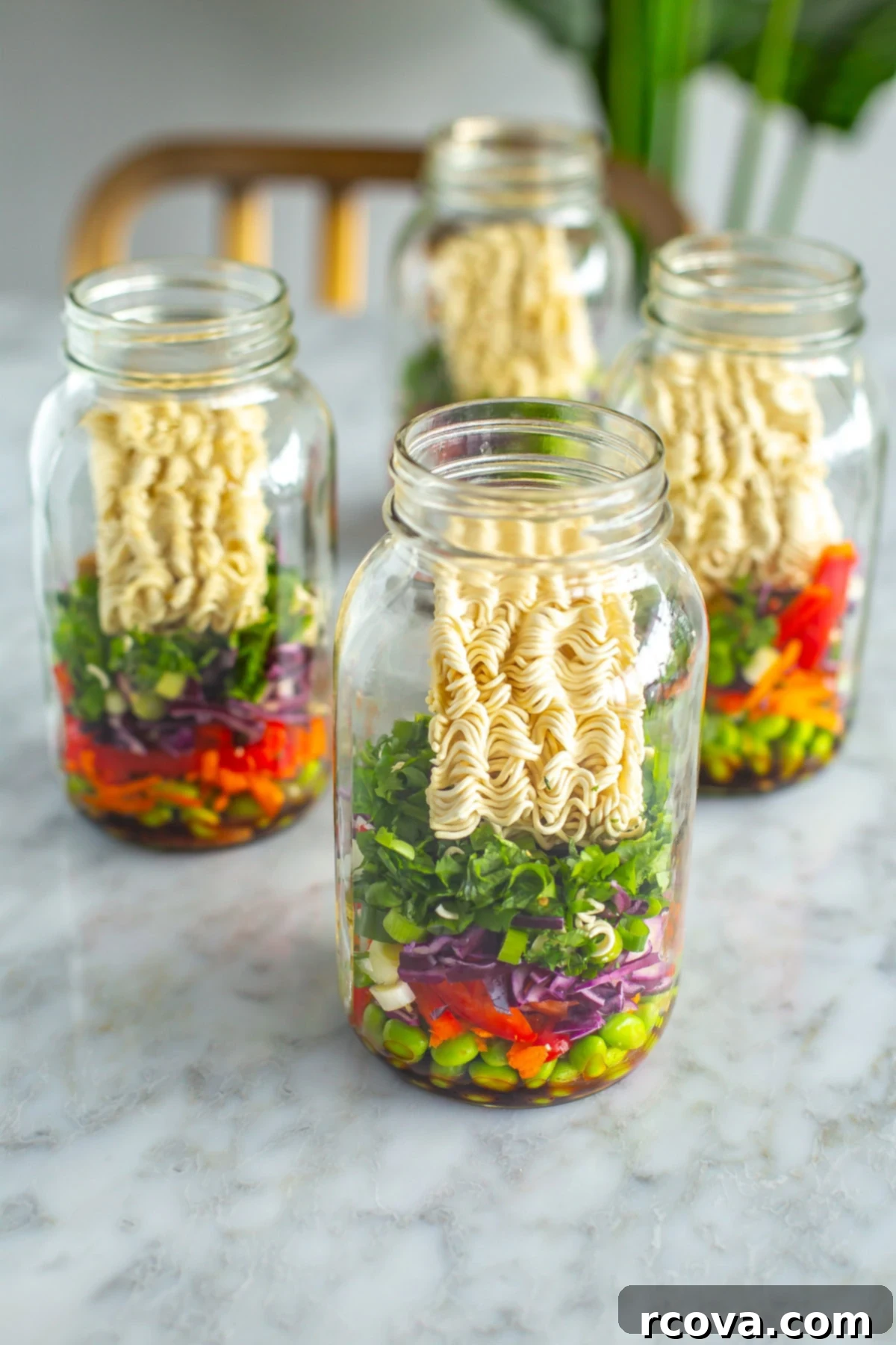 35+ Healthy and Easy Recipes Under 500 Calories 19 Four beautifully layered mason jars, each filled with homemade instant noodles, fresh vegetables, and fragrant herbs, ready for hot water.