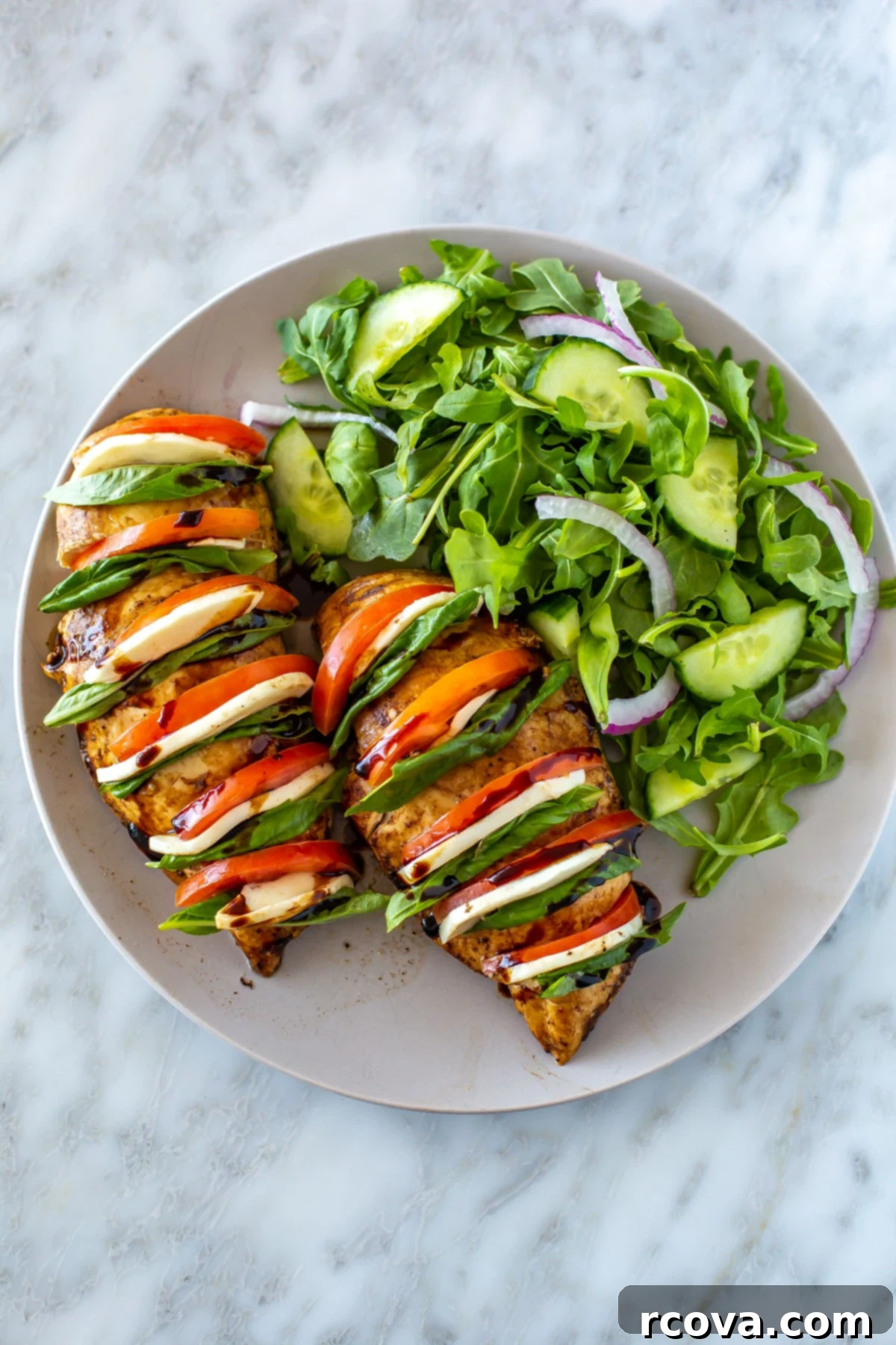 35+ Healthy and Easy Recipes Under 500 Calories 30 A delightful plate of Hasselback Baked Caprese Chicken served alongside a fresh side salad, capturing the essence of summer flavors.
