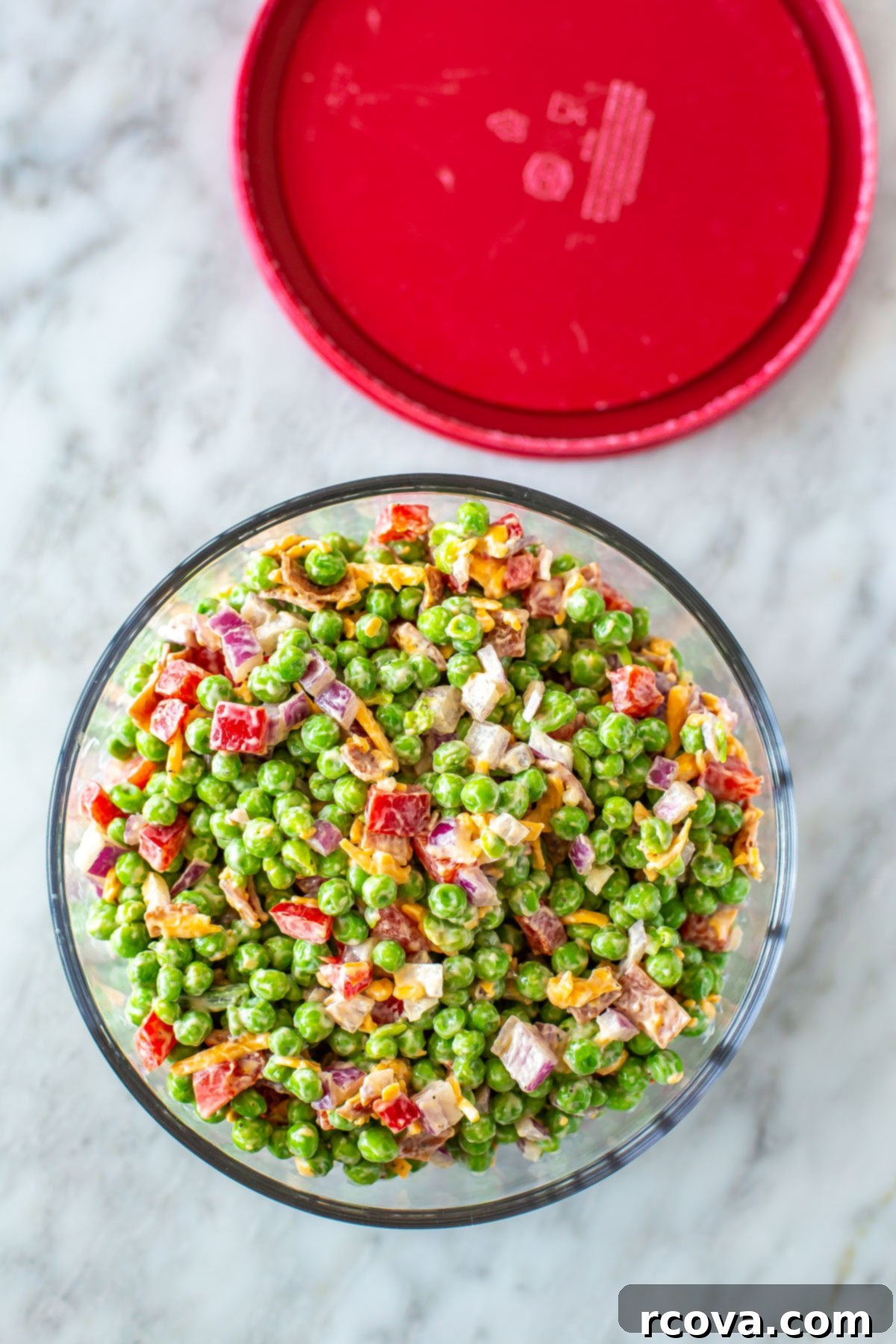 Creamy Pea Salad Perfection 8 Creamy pea salad in a glass meal prep bowl with the lid off to the side.
