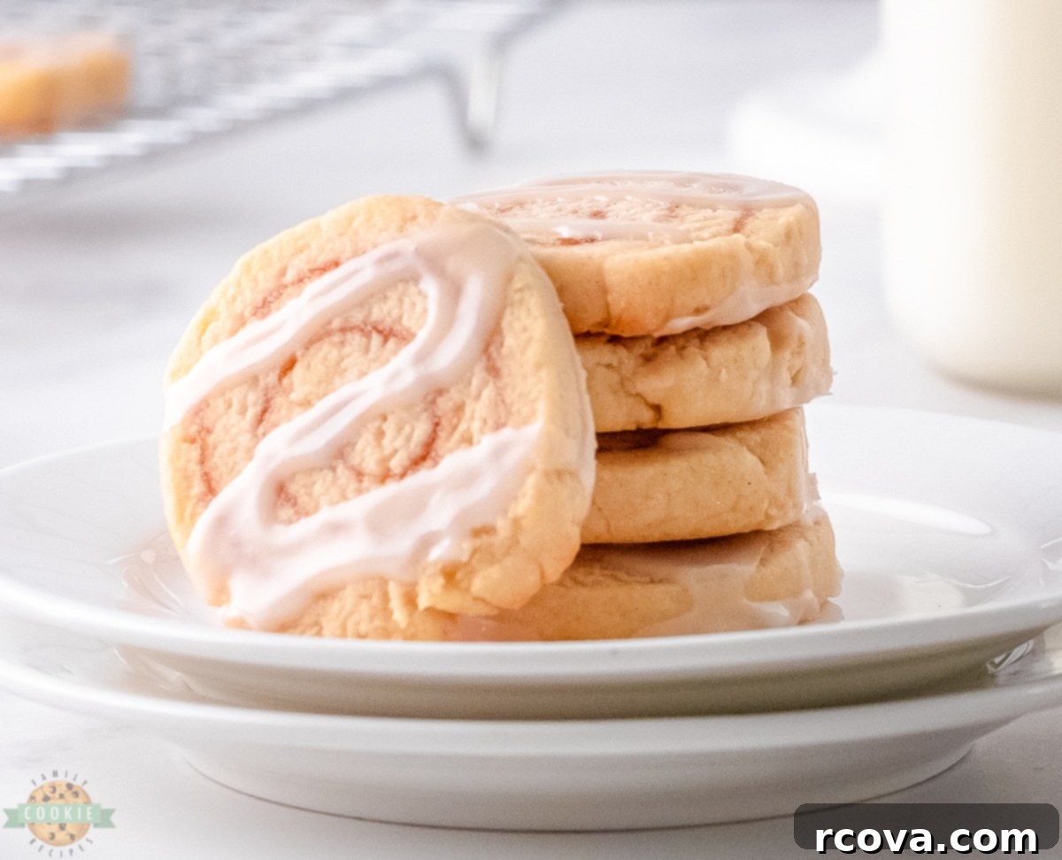 Cinnamon Bun Bliss Cookies 2 Close-up of freshly baked cinnamon roll cookies drizzled with vanilla icing.