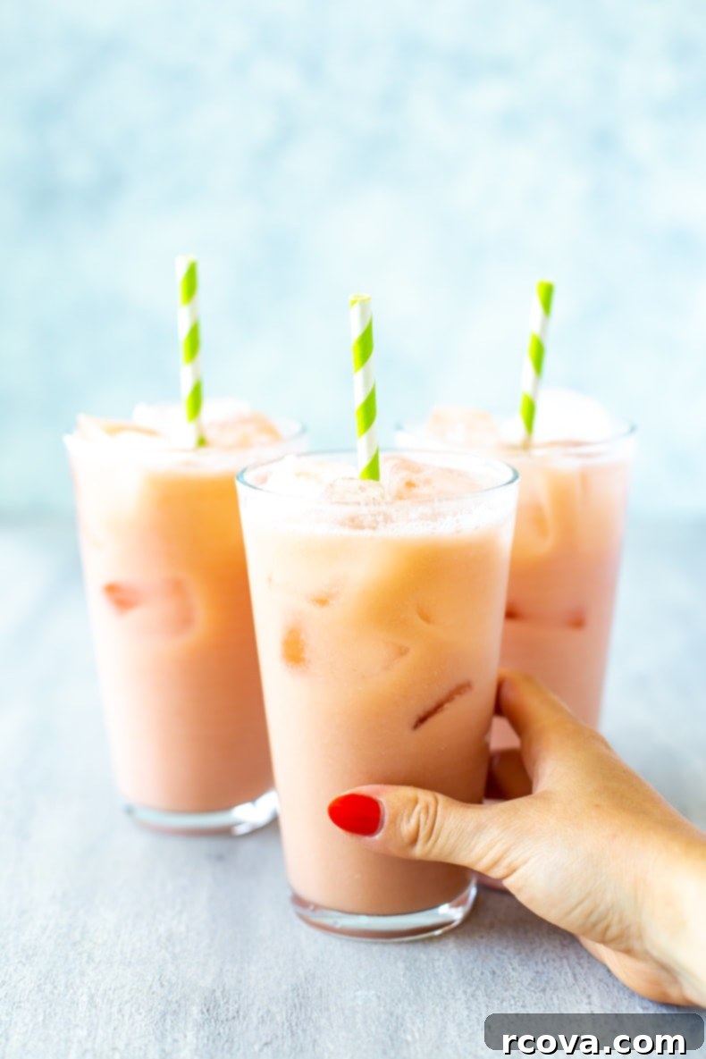 Make Your Own Starbucks Summer Drinks At Home 16 A glass of homemade Iced Guava Passionfruit Drink, with tropical fruit slices.