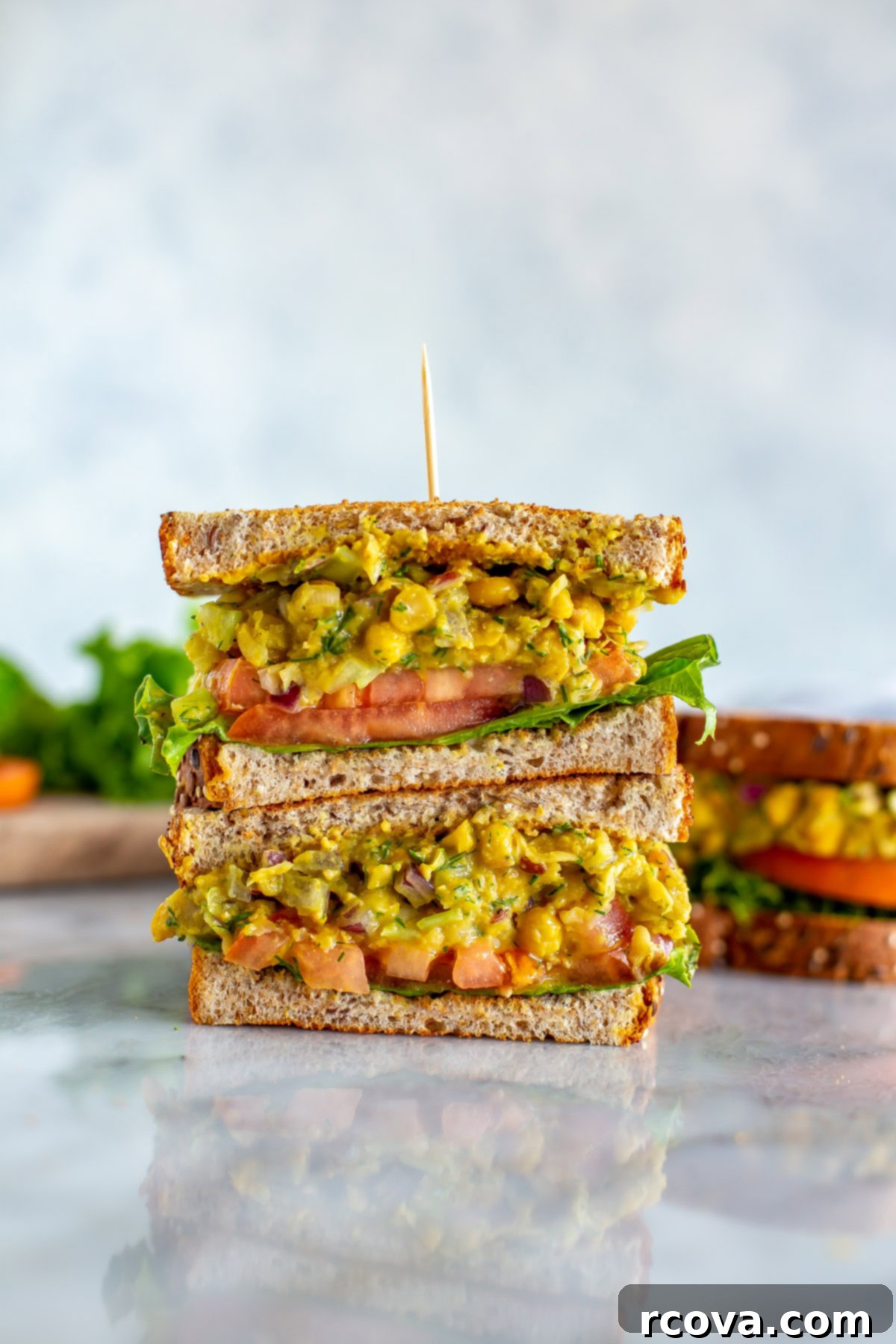 Chickpea Tuna Salad Sandwich: A Vegetarian Delight 7 Two halves of a chickpea tuna salad sandwich stacked together with a toothpick, showing the vibrant filling.