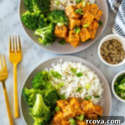 Master Crispy Air Fryer Tofu with Our Ultimate Sauce 11 Two plates of air fryer tofu served alongside rice and broccoli.