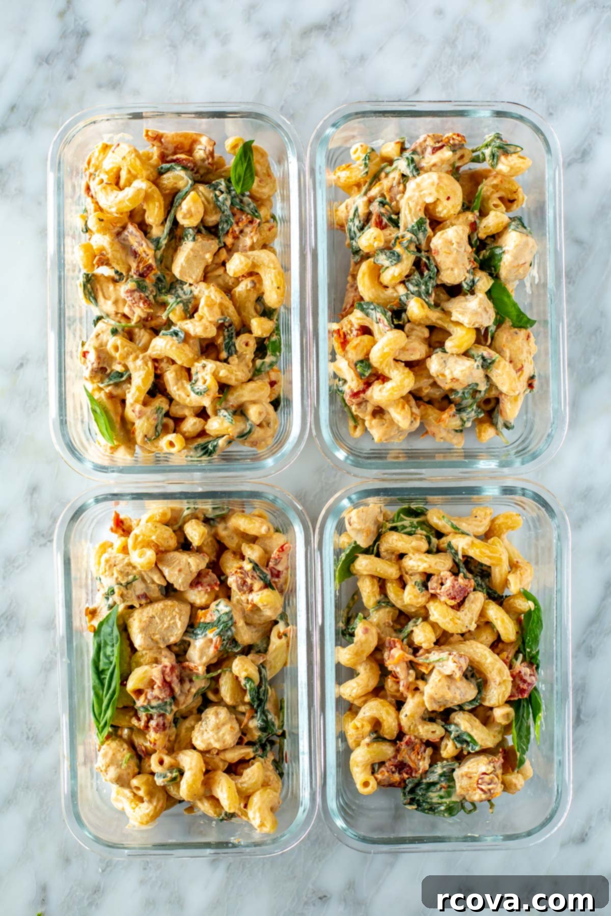 Effortless Creamy Sun-Dried Tomato Pasta 10 Four individual meal prep containers neatly packed with servings of creamy sundried tomato pasta, ready for the week.