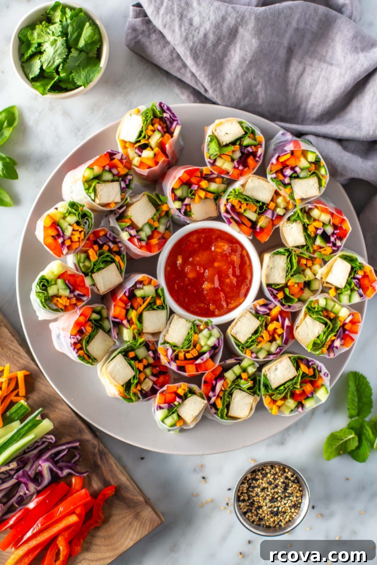 Plant-Powered Summer Rolls with Zesty Chili Dip 2 A large plate of summer rolls with a little bowl of sweet chili sauce in the middle.