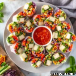Plant-Powered Summer Rolls with Zesty Chili Dip 11 A large plate of summer rolls with a little bowl of sweet chili sauce in the middle.
