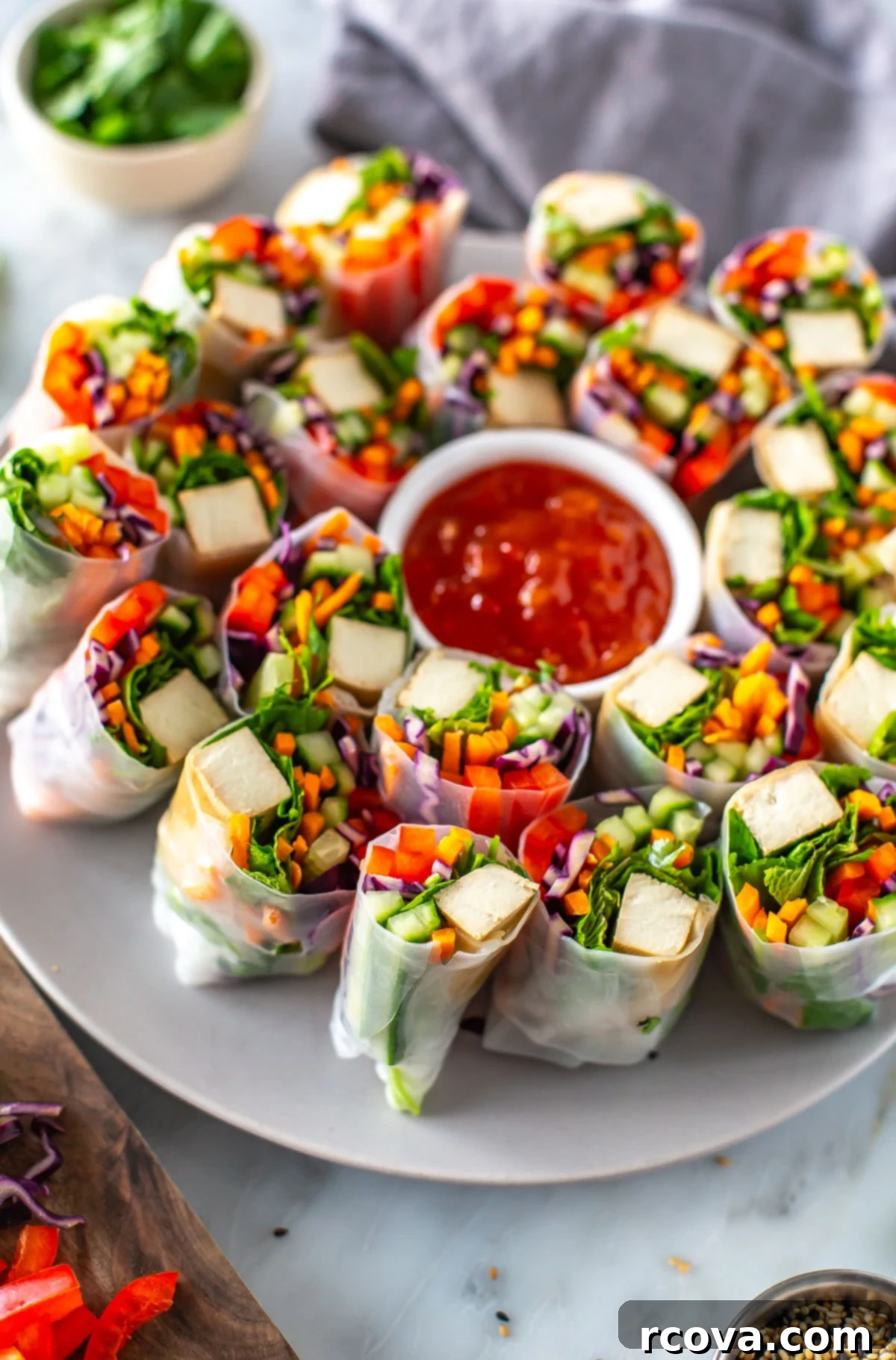 Plant-Powered Summer Rolls with Zesty Chili Dip 9 A plate of summer rolls with a bowl of sweet chili sauce in the middle.