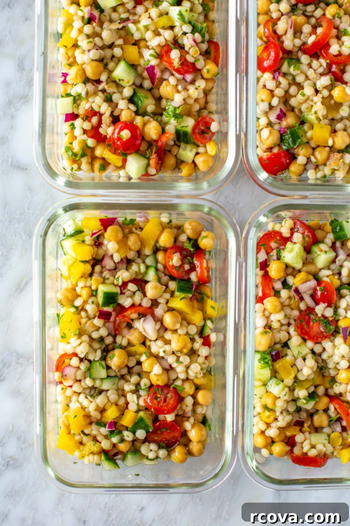 Effortless Mediterranean Couscous Salad for Meal Prep 7 A close-up of 4 glass meal prep containers, each filled with a generous serving of colorful Mediterranean couscous salad.