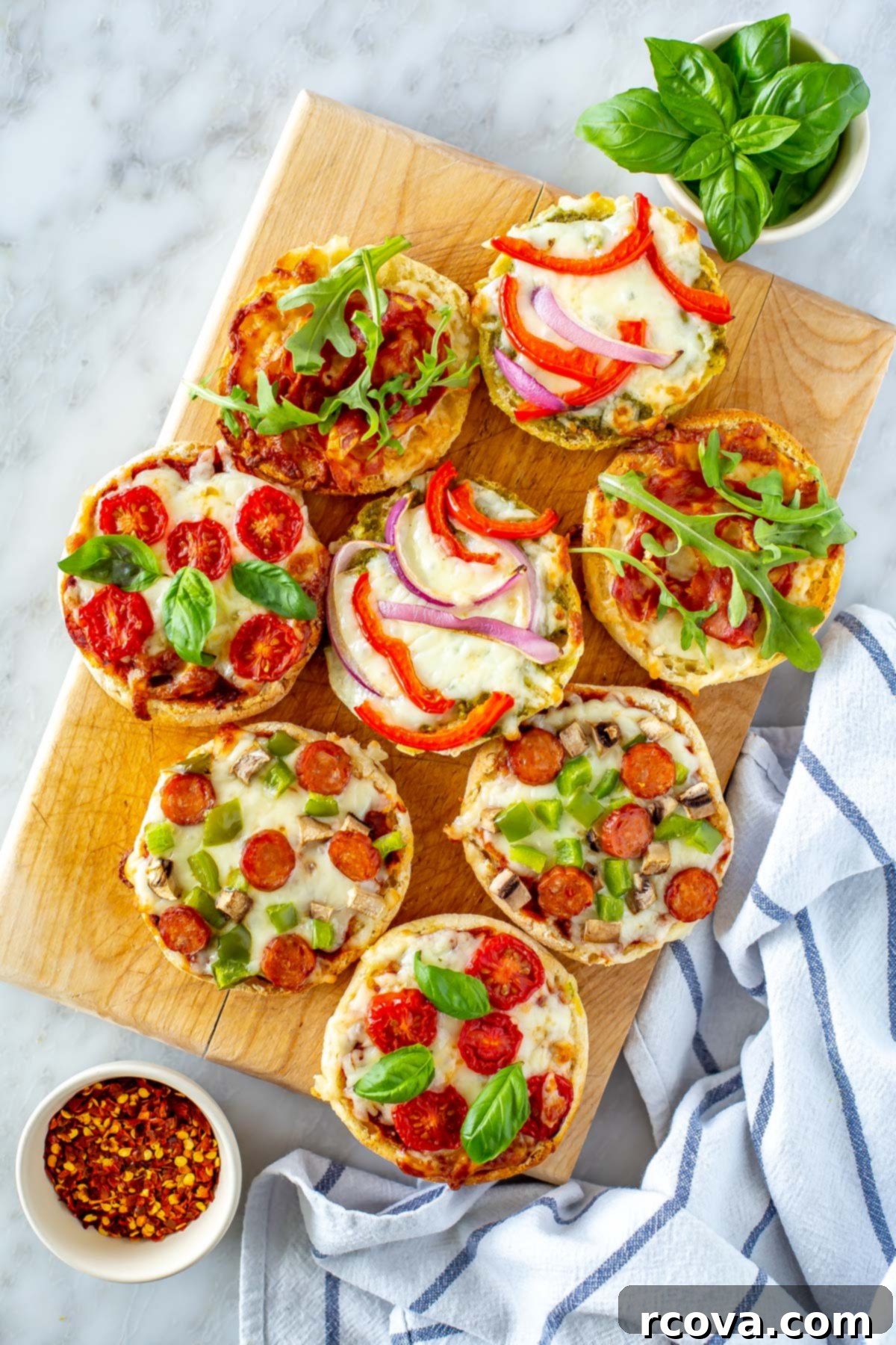 Simple Potluck Showstoppers 21 Several different English muffin pizzas on a butcher block.