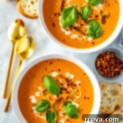 Sun-Kissed Roasted Tomato Basil Bliss 10 Two bowls of roasted tomato basil soup with baguette slices placed around it.