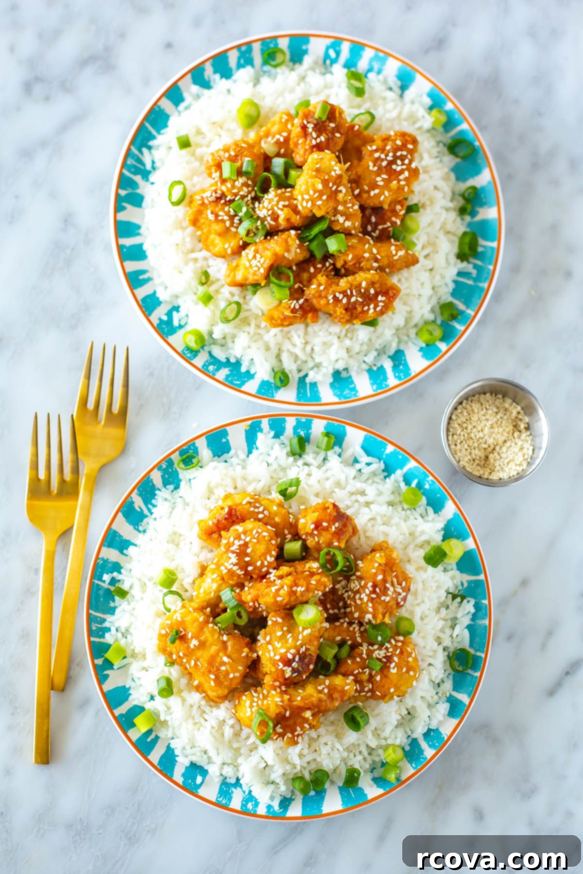 25+ Healthy Meals to Satisfy Even the Fussiest Eaters 10 Two plates of copycat Panda Express orange chicken.