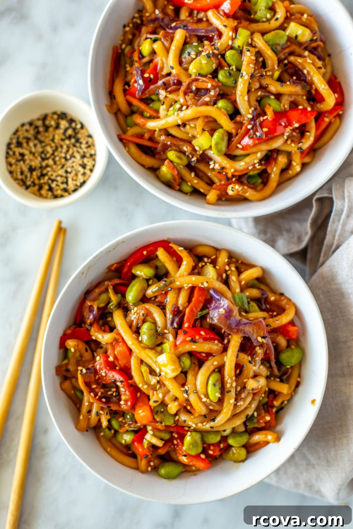 Quick 15-Minute Udon 2 Two bowls of vibrant stir-fried udon noodles, garnished with fresh green onions and sesame seeds, ready to be enjoyed.