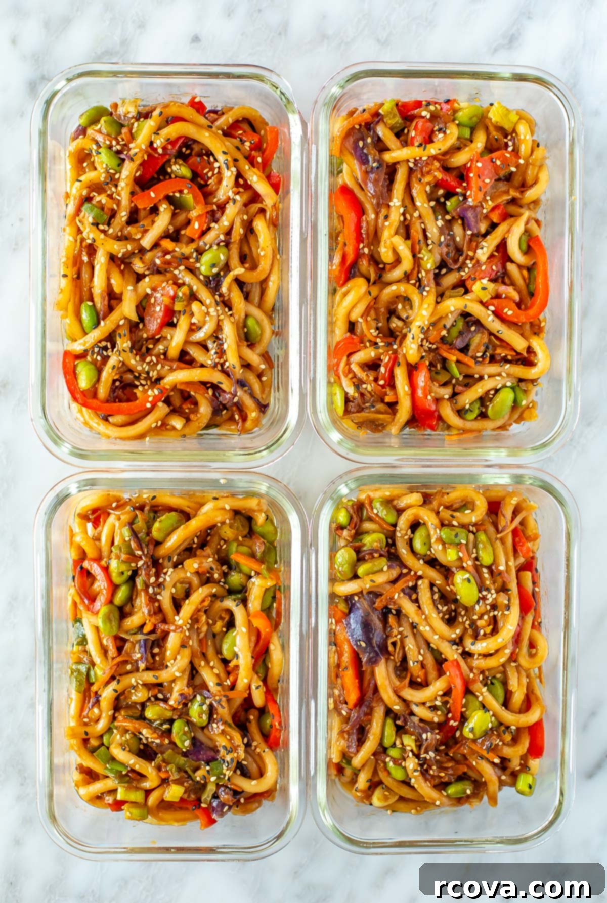 Quick 15-Minute Udon 9 Four perfectly portioned meal prep containers, each filled with a serving of stir-fried udon noodles, showcasing the recipe's suitability for healthy meal planning.