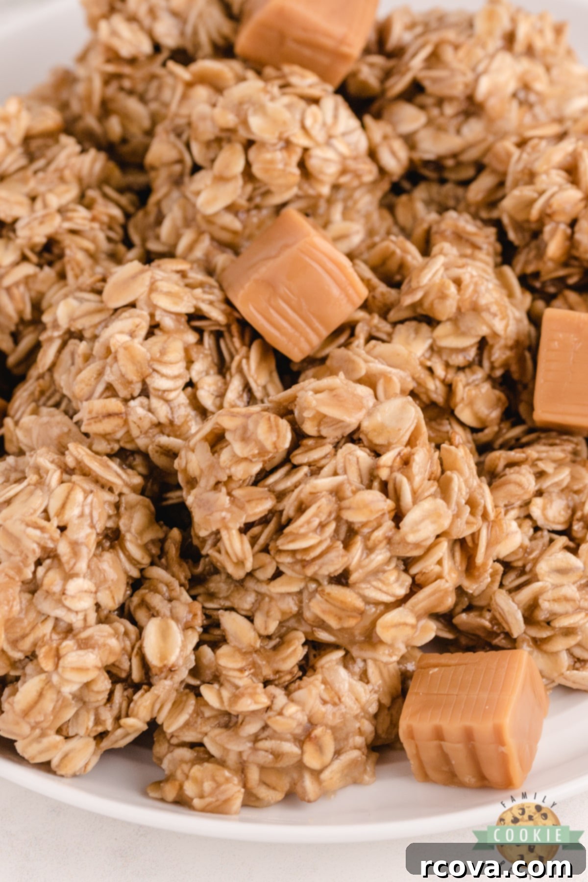 Dreamy Caramel Oat No Bake Bites 3 A stack of Caramel Oatmeal No Bake Cookies on a rustic wooden board, garnished with a sprinkle of sea salt and a small bowl of melted caramel.
