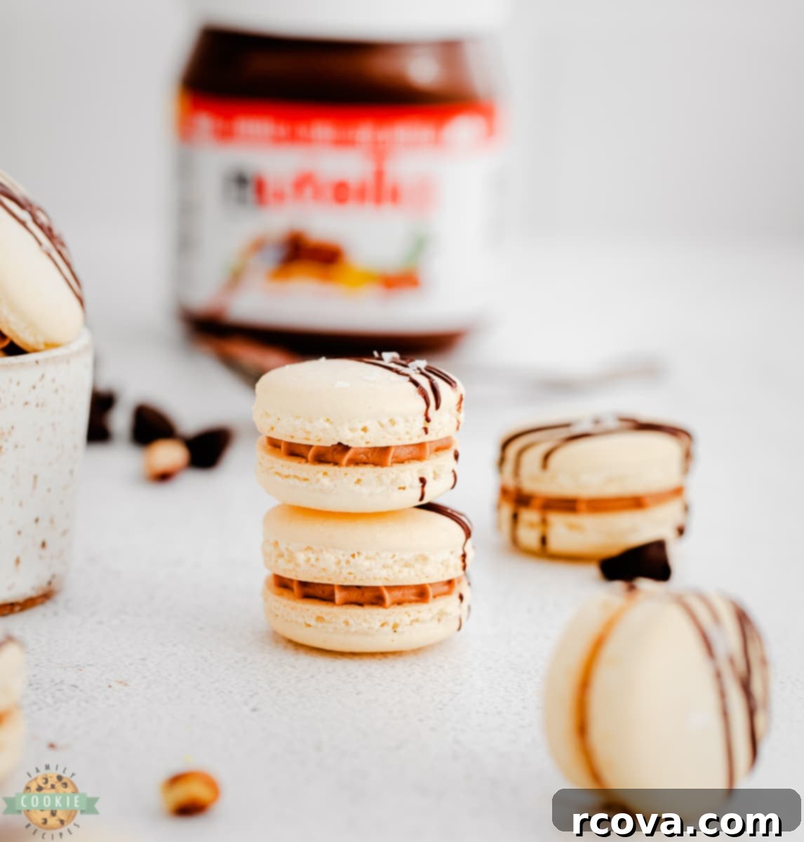 Decadent Nutella Macarons 5 Hands carefully folding dry ingredients into the meringue batter for Nutella Macarons, emphasizing the macaronage process.
