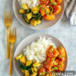 Explosive Firecracker Chicken Dinner 11 Two plates of firecracker chicken with rice and zucchini.