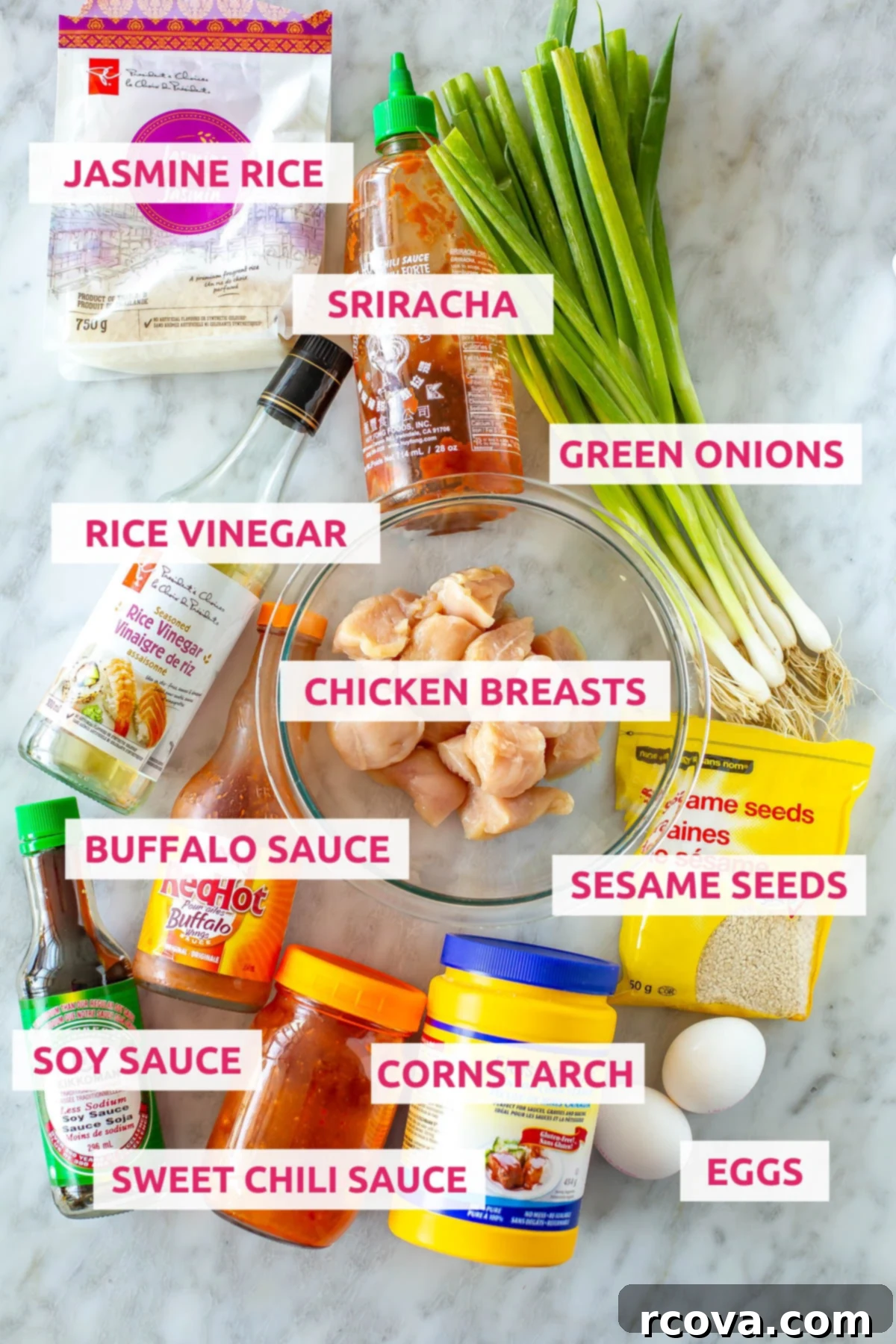 Explosive Firecracker Chicken Dinner 4 A vibrant flat lay of all ingredients for homemade Firecracker Chicken, including chicken breasts, jasmine rice, rice vinegar, buffalo sauce, soy sauce, sweet chili sauce, sriracha, eggs, cornstarch, sesame seeds, and fresh green onions.