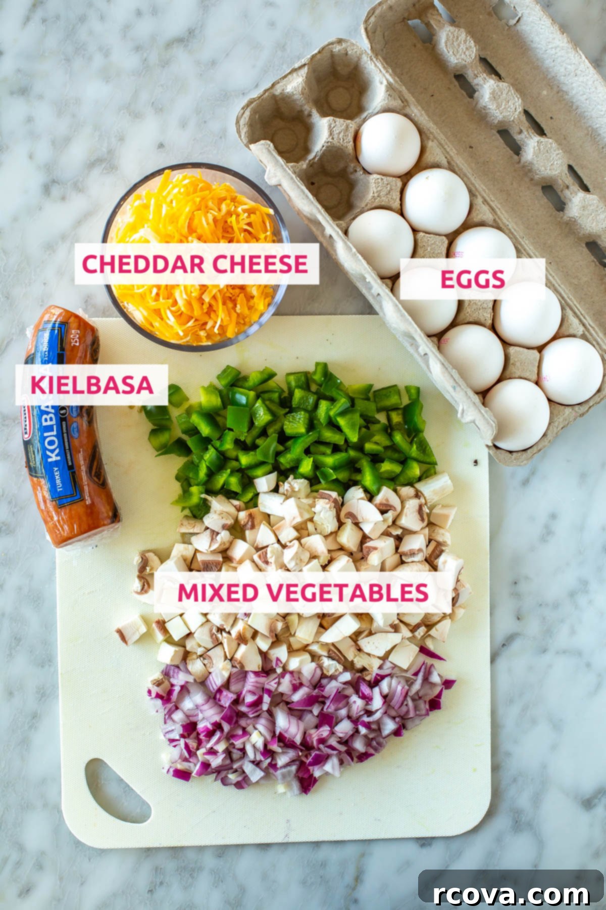 Microwave Omelette Meal Prep 4 Ingredients for microwave omelettes laid out: fresh eggs, shredded cheddar cheese, sliced kielbasa, and a colorful mix of diced vegetables like peppers, onions, and mushrooms.