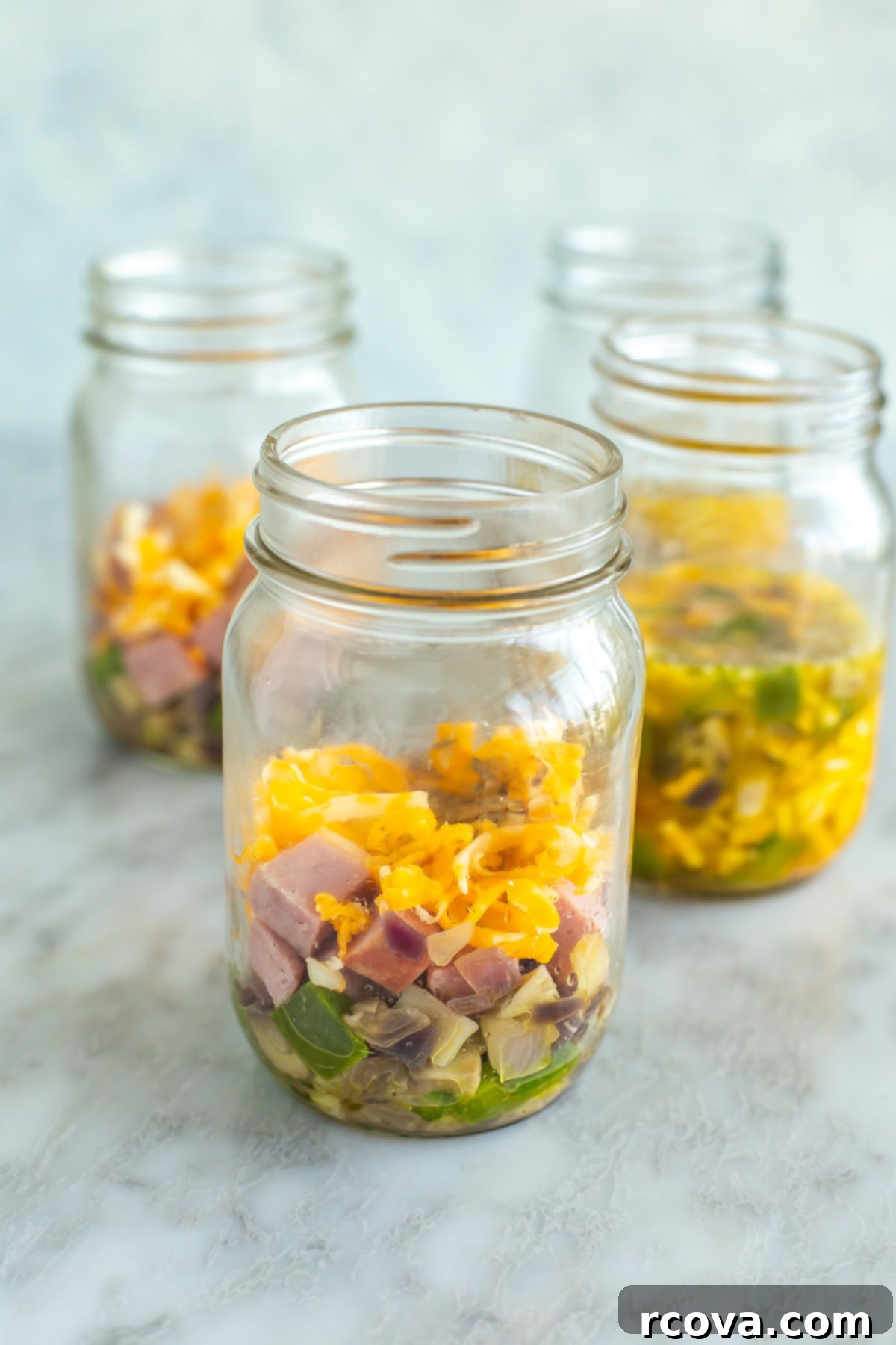 Microwave Omelette Meal Prep 7 Four perfectly cooked microwave omelettes arranged in individual mason jars, ready to eat.