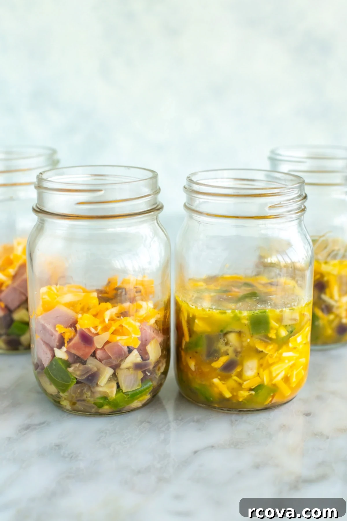 Microwave Omelette Meal Prep 8 Four freshly prepared microwave omelettes in mason jars, showcasing their vibrant ingredients and fluffy texture.