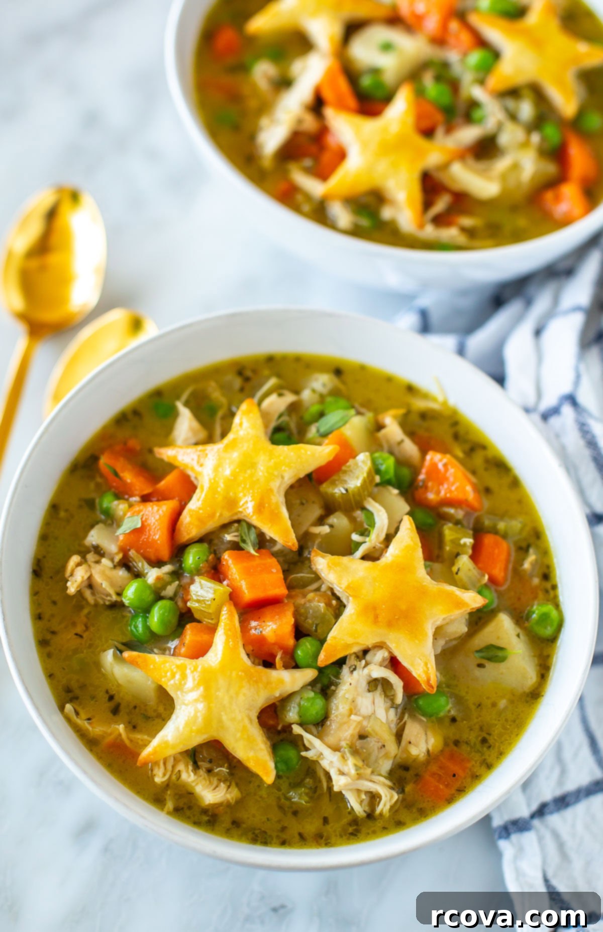 Wholesome Chicken Pot Pie Soup 8 A close-up of a single bowl of healthy chicken pot pie soup, garnished with star-shaped puff pastry croutons and fresh herbs, showcasing its creamy texture and rich ingredients.