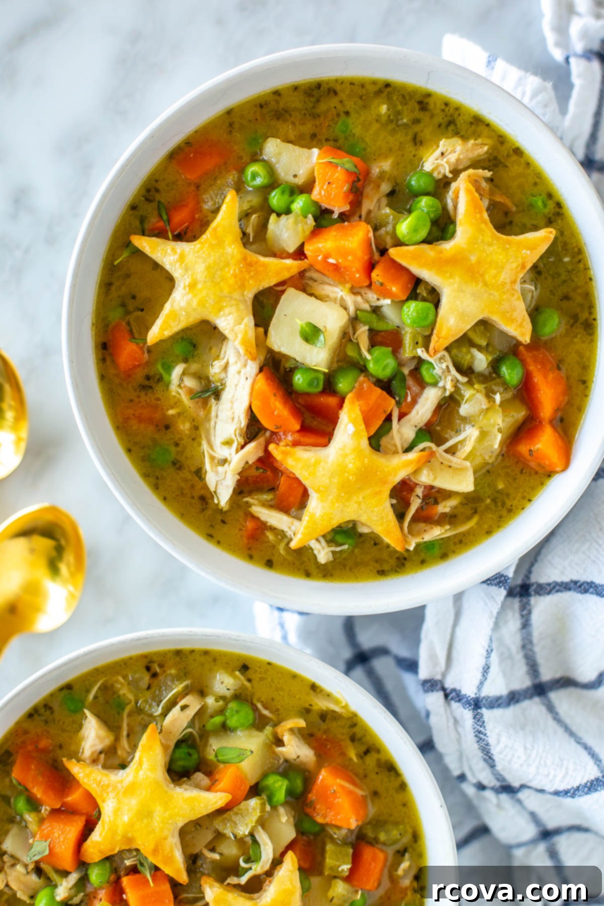 Wholesome Chicken Pot Pie Soup 9 A close-up view of a steaming bowl of homemade healthy chicken pot pie soup, topped with golden star-shaped puff pastry pieces, perfect for a cozy meal.