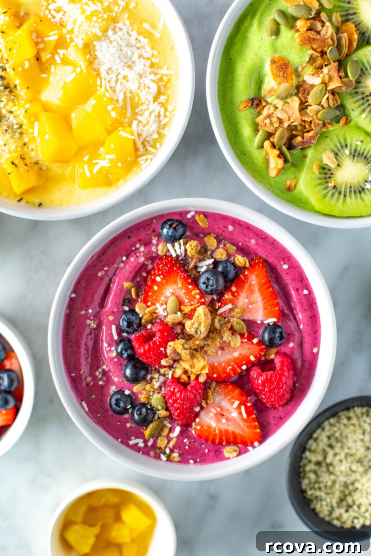 Whip Up Amazing Smoothie Bowls 8 Three perfectly thick and colorful smoothie bowls, each adorned with a generous and aesthetically pleasing assortment of healthy toppings like seeds, nuts, and fresh fruit, ready to be enjoyed as a wholesome breakfast.