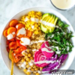 Vibrant Rainbow Harvest Bowl 10 A vibrant rainbow veggie bowl with a creamy garlic dressing drizzled generously on top, showcasing a healthy and delicious plant-based meal.
