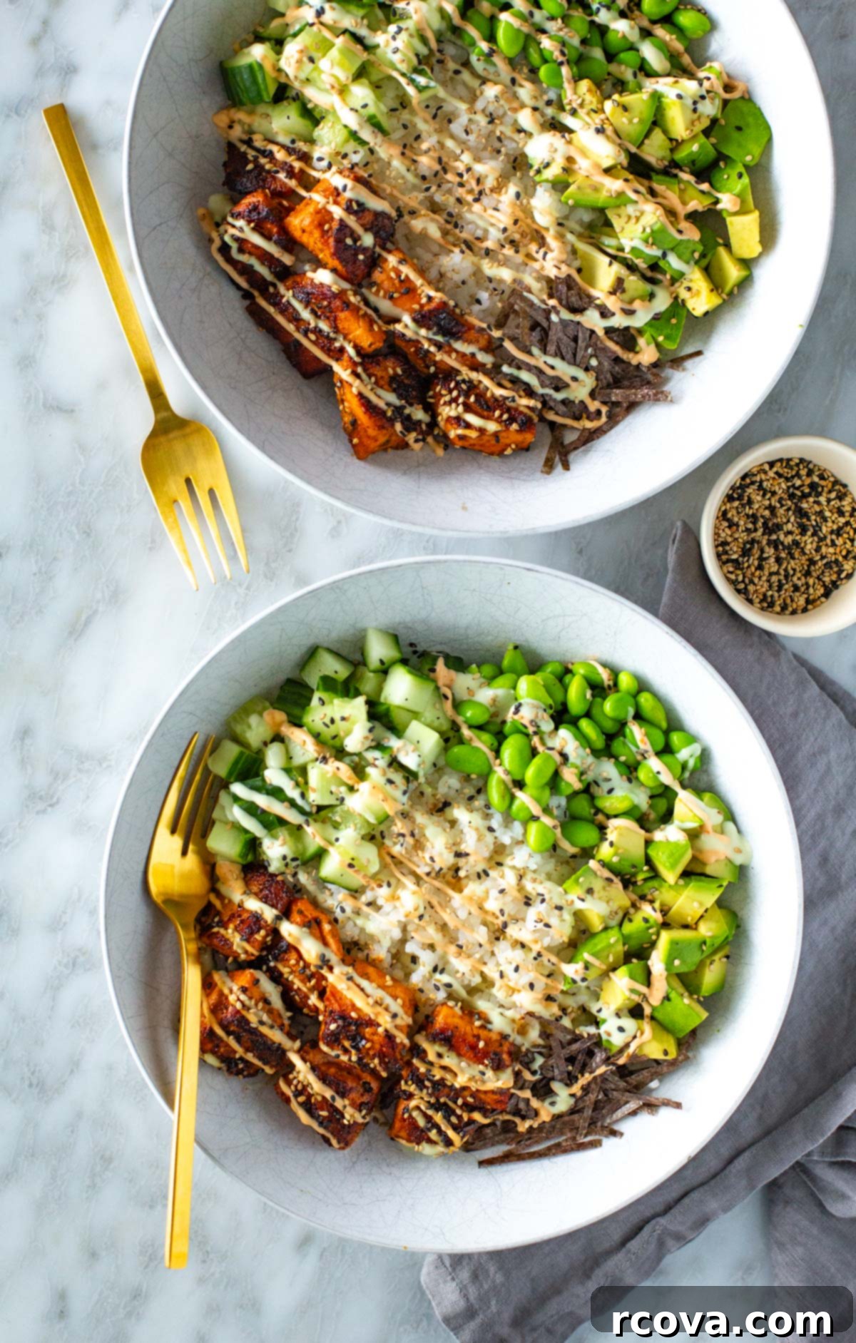 Effortless Spicy Salmon Sushi Bowls 2 Two homemade spicy salmon sushi bowls, garnished with sesame seeds and fresh vegetables.