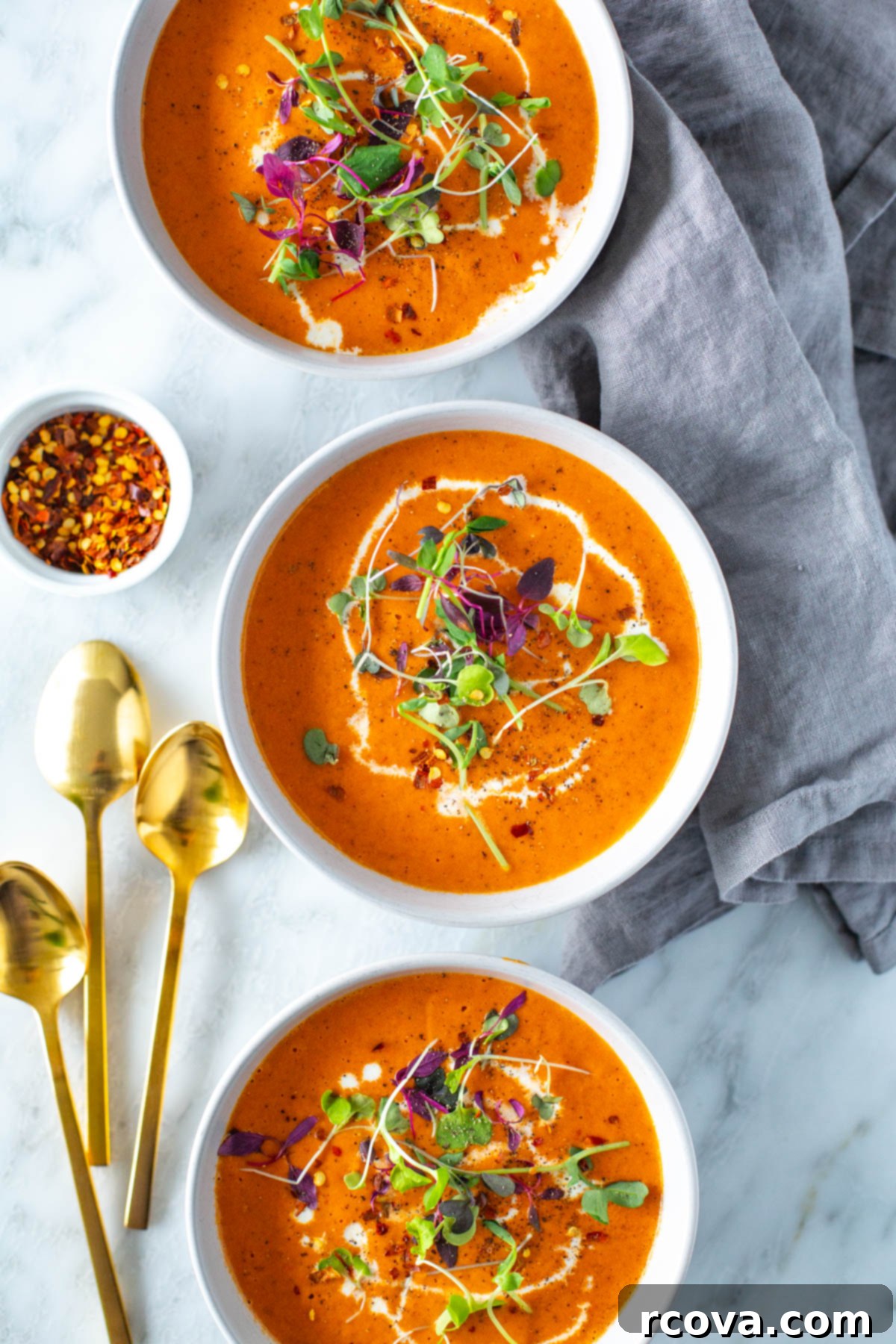 Smoky Red Pepper Bisque 8 Bowls of roasted red pepper soup with gold spoons on the side