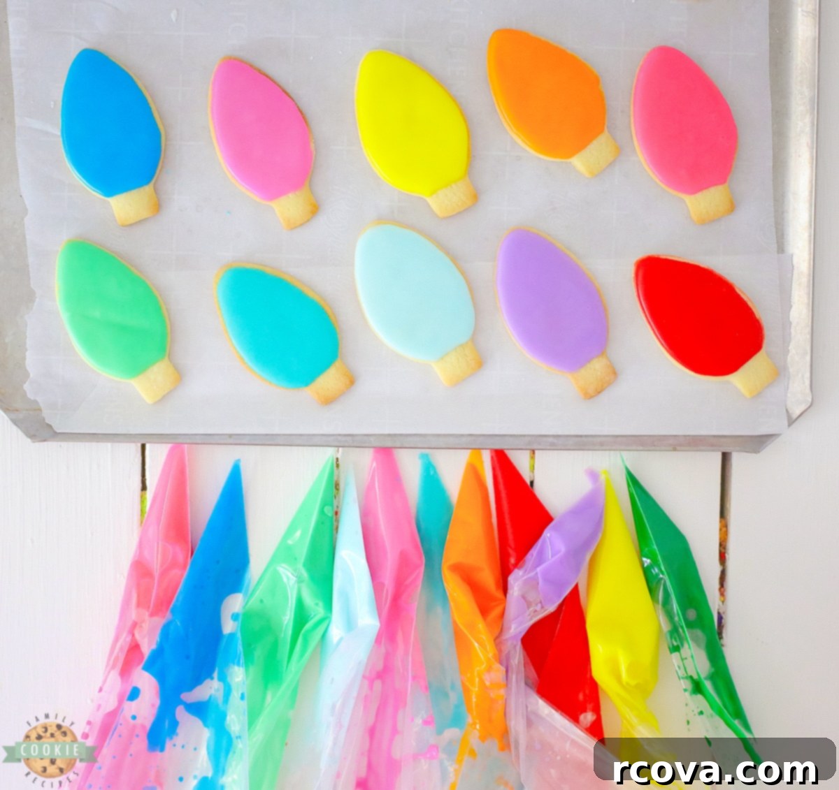 Twinkling Christmas Light Cookies 5 A selection of colorful holiday Christmas Lights Cut Out Cookies, decorated with bright icing and black bases, arranged on a white surface.