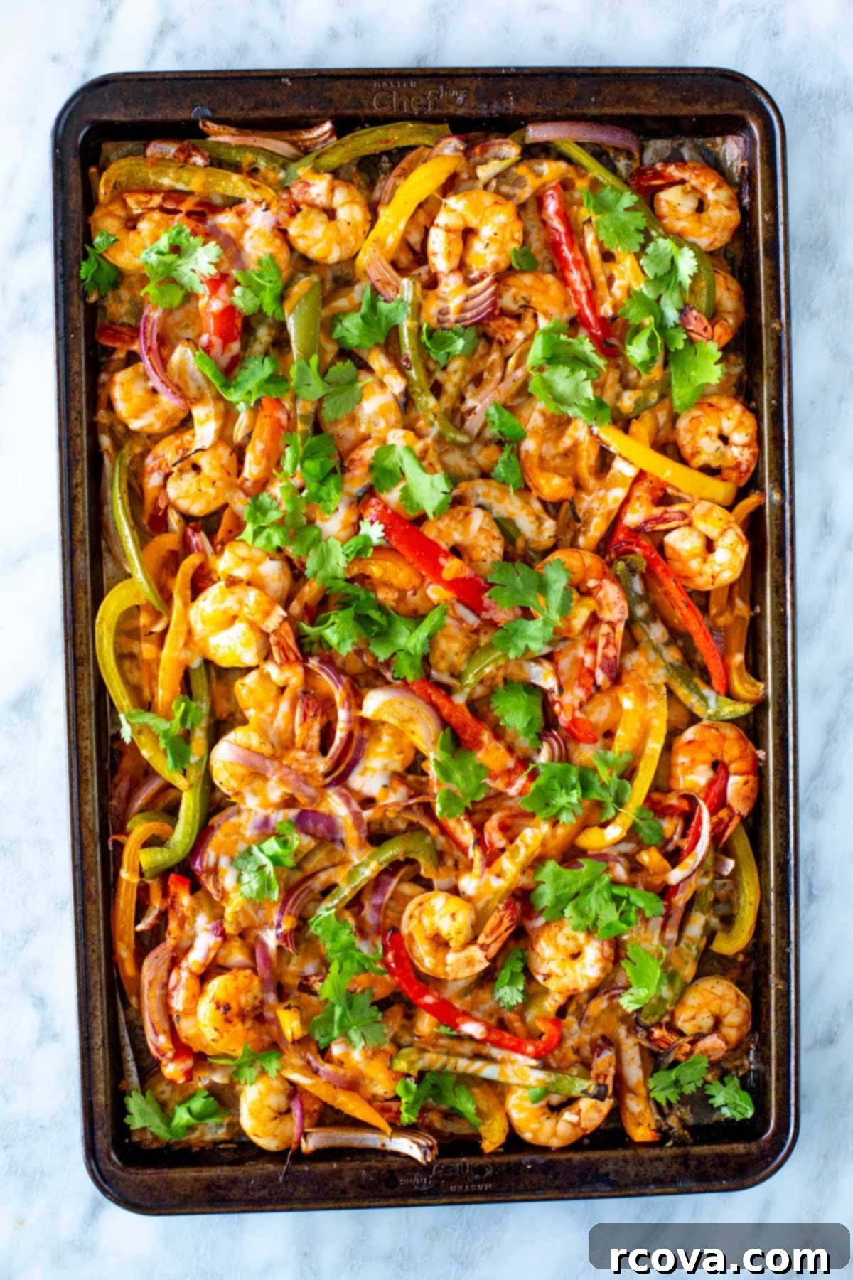 Effortless Sheet Pan Shrimp Fajitas 2 Close-up of freshly cooked sheet pan shrimp fajitas, garnished with vibrant cilantro and lime wedges, ready to be served.