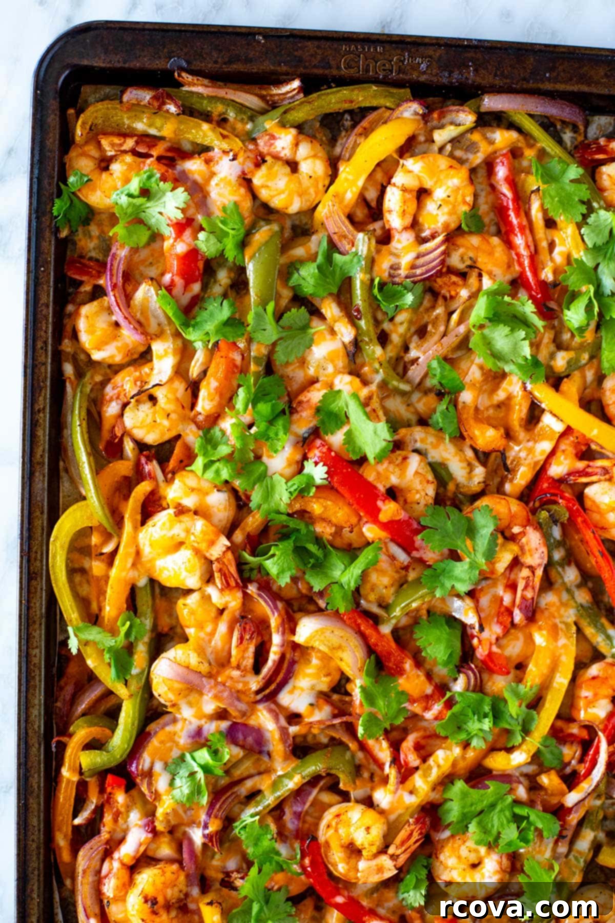 Effortless Sheet Pan Shrimp Fajitas 8 A sheet pan loaded with cooked shrimp, colorful bell peppers, and red onion, fresh out of the oven.