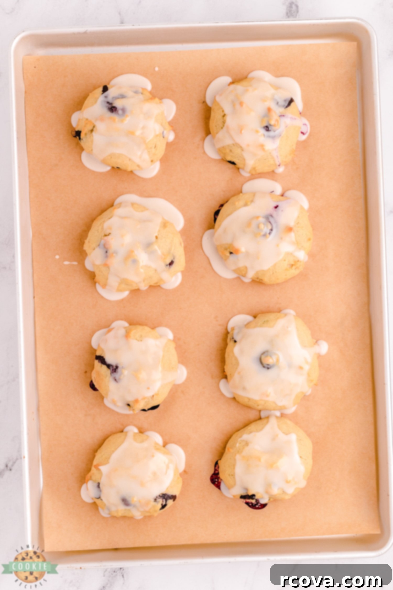 Blueberry Banana Cookie Delights 6 iced blueberry banana cookies on a baking sheet