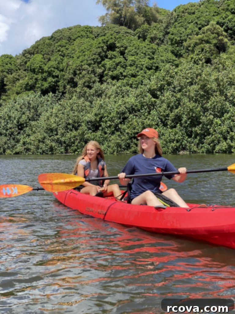 Almond Kissed Delights 13 Two girls enjoying a kayak trip on a river in Kauai, surrounded by lush scenery.