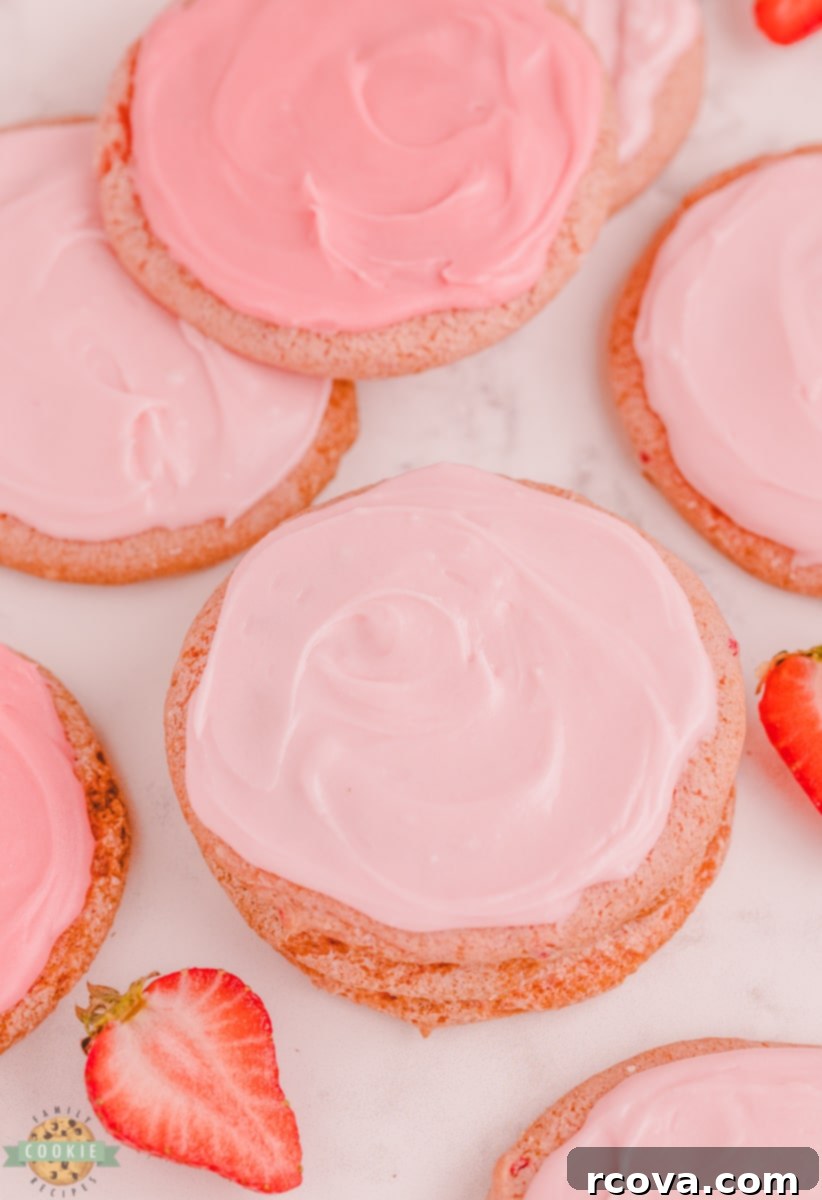 Strawberry Whipped Dream Cookies 8 A stack of strawberry cool whip cookies with glaze, garnished with a fresh strawberry slice