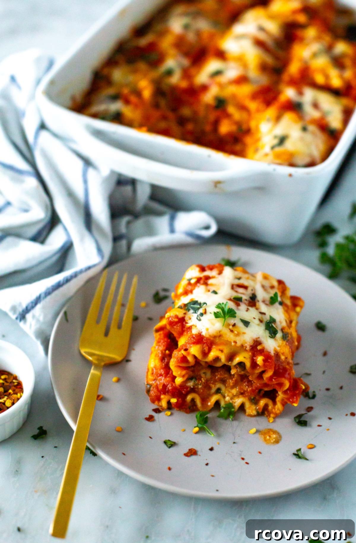 Effortless Lasagna Roll-Ups: A Delicious Family Meal 2 A plate of cheesy spinach lasagna roll-ups topped with melted mozzarella cheese and garnished with fresh basil.