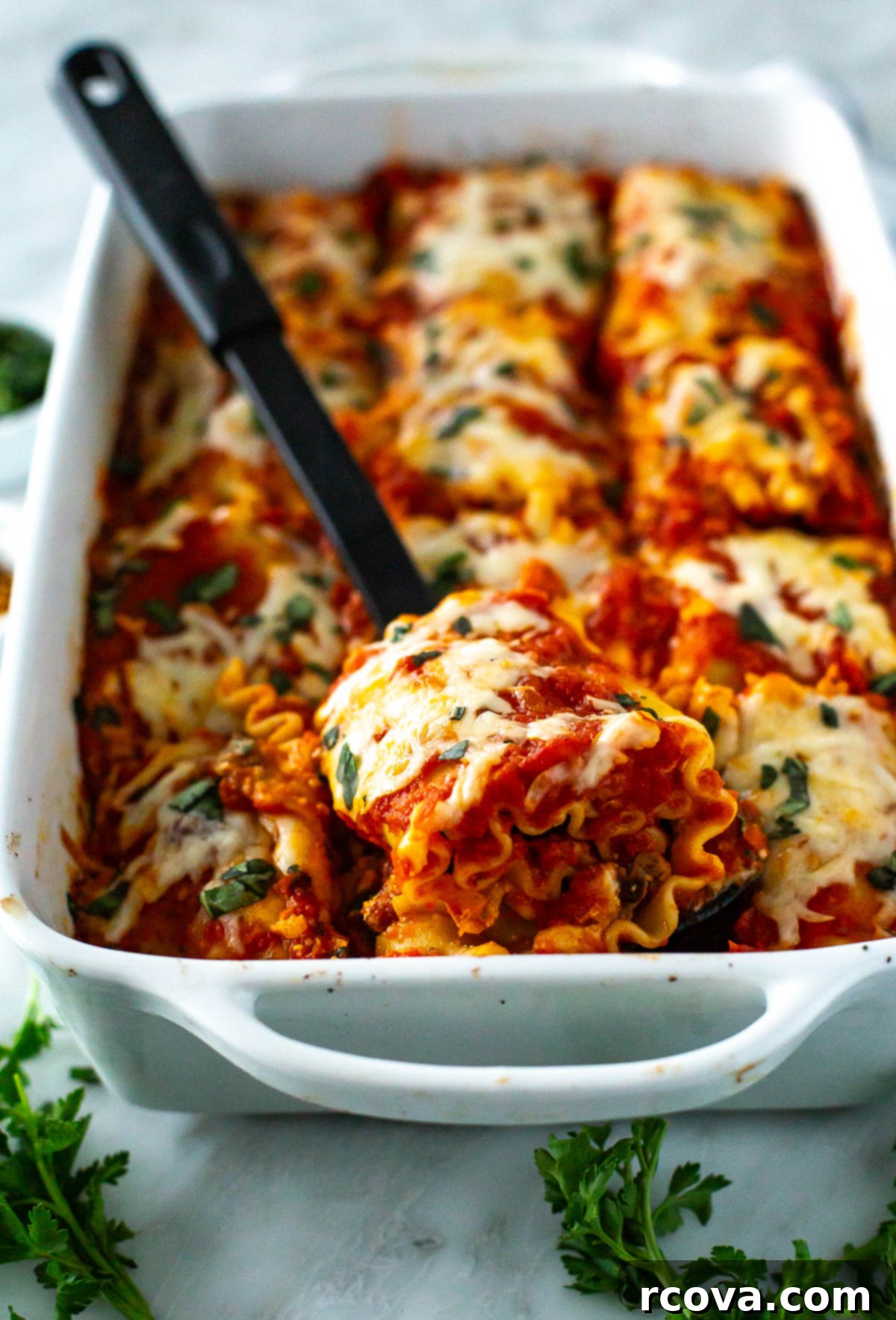 Effortless Lasagna Roll-Ups: A Delicious Family Meal 9 Close up of lasagna roll-ups fresh out of the oven, one piece lifted by spatula