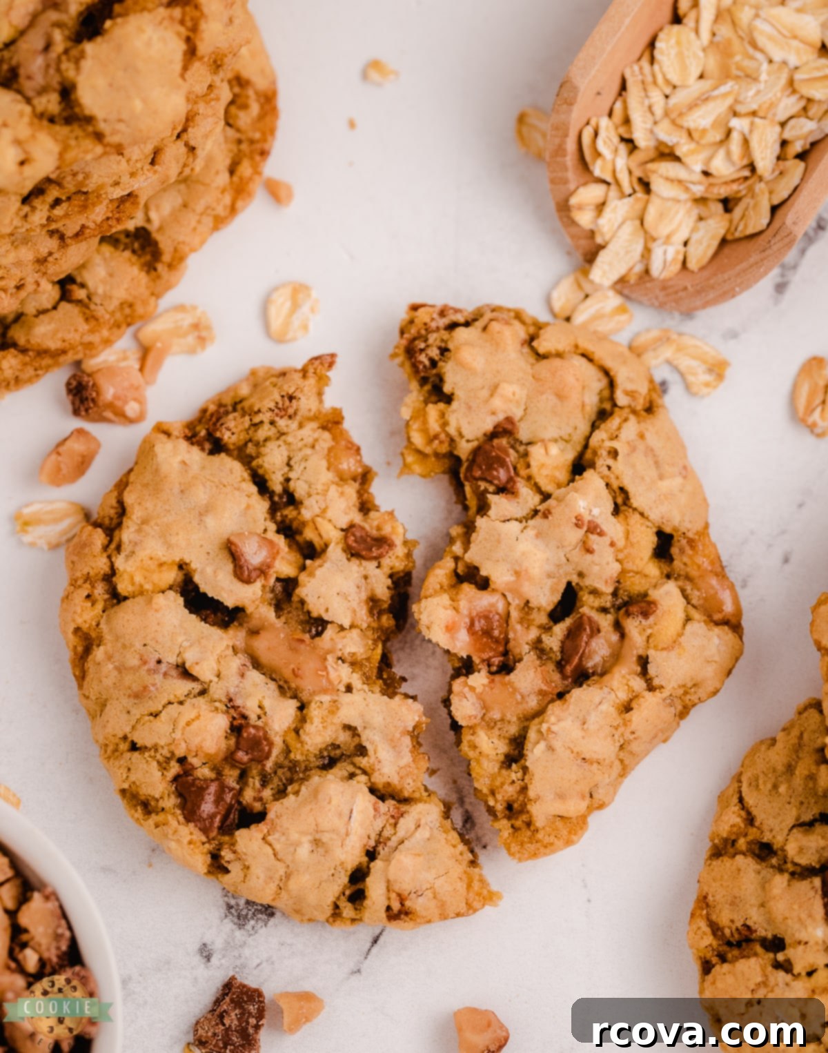 Chewy Toffee Oatmeal Delights 11 Toffee Oatmeal Cookie broken in half, revealing its chewy interior and scattered toffee bits