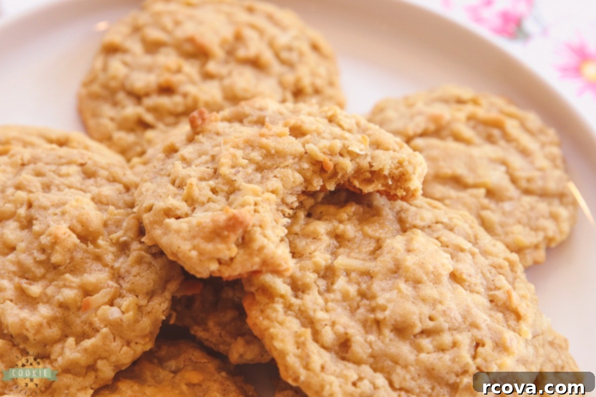 Chewy Coconut Oatmeal Delights 3 A close-up of a coconut oatmeal cookie with a bite taken out, showing the soft interior and generous amount of coconut.