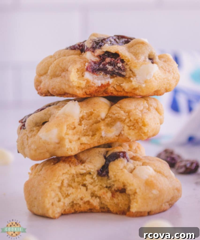 Irresistible Homemade Chocolate Chip Cookie Recipes 49 A stack of White Chocolate Cherry Cookies, showing vibrant red cherry pieces.