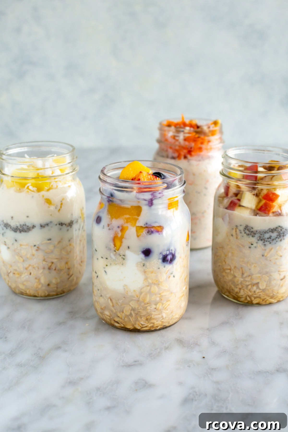 30g Protein Power Overnight Oats 2 side front shot of four mason jars with high protein overnight oats, each with different vibrant toppings like berries, mango, and nuts