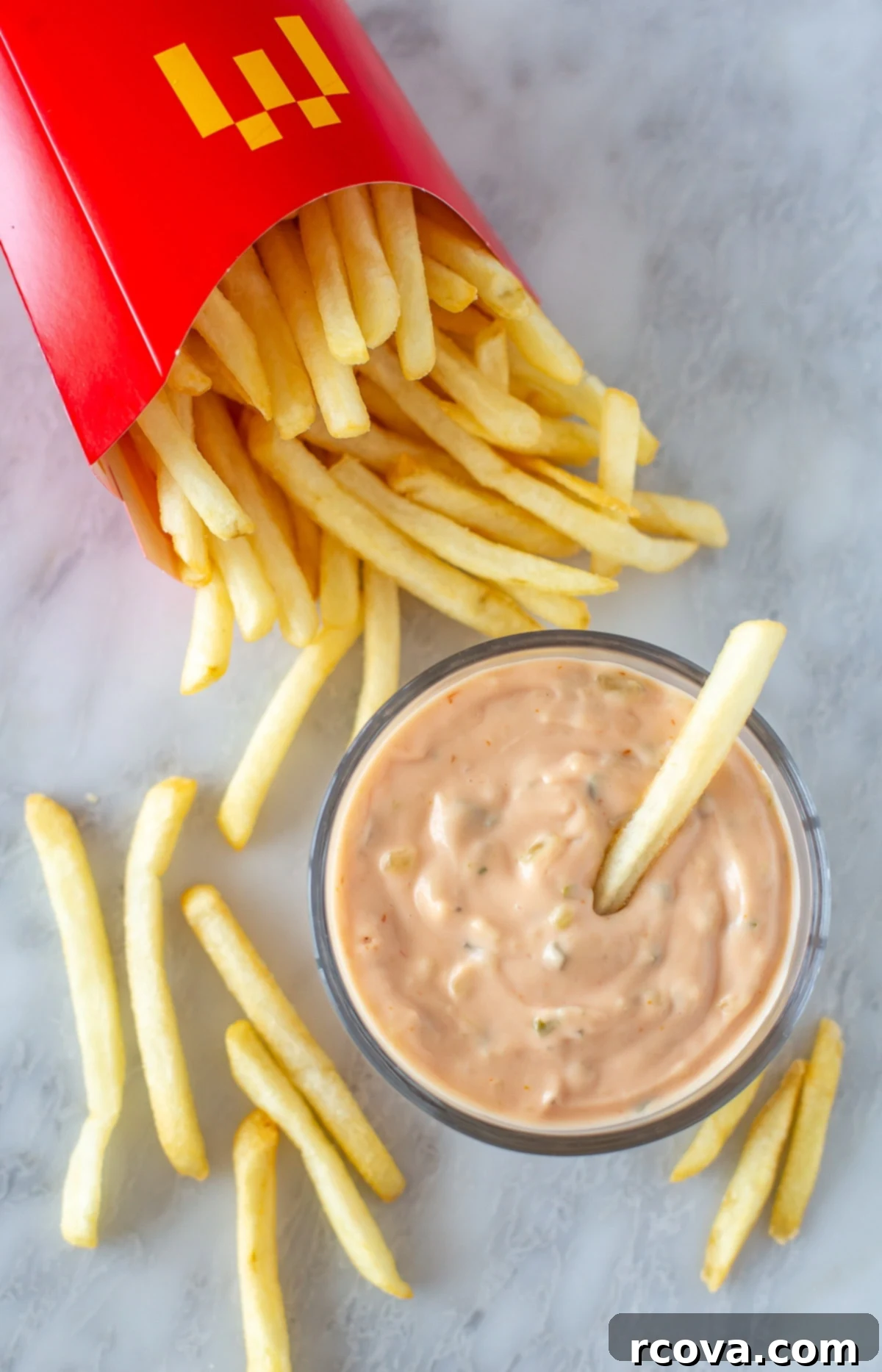 Your 3-Ingredient Big Mac Sauce Secret 7 Overhead shot of Big Mac sauce in a small bowl, next to crispy French fries on a dark background.