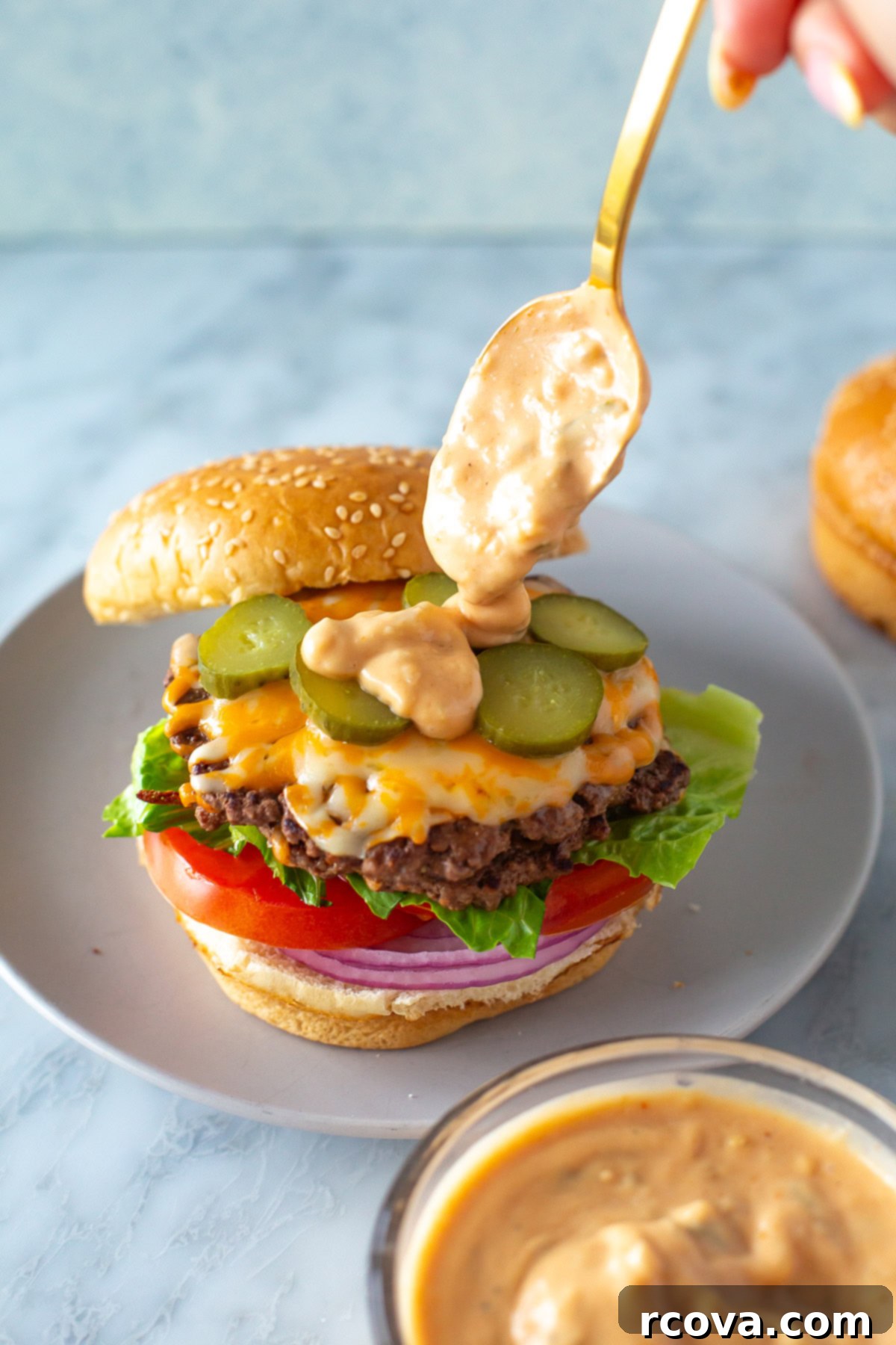 Signature Burger Sauce 8 Overhead shot of a juicy burger, generously drizzled with the homemade special burger sauce, on a plate.
