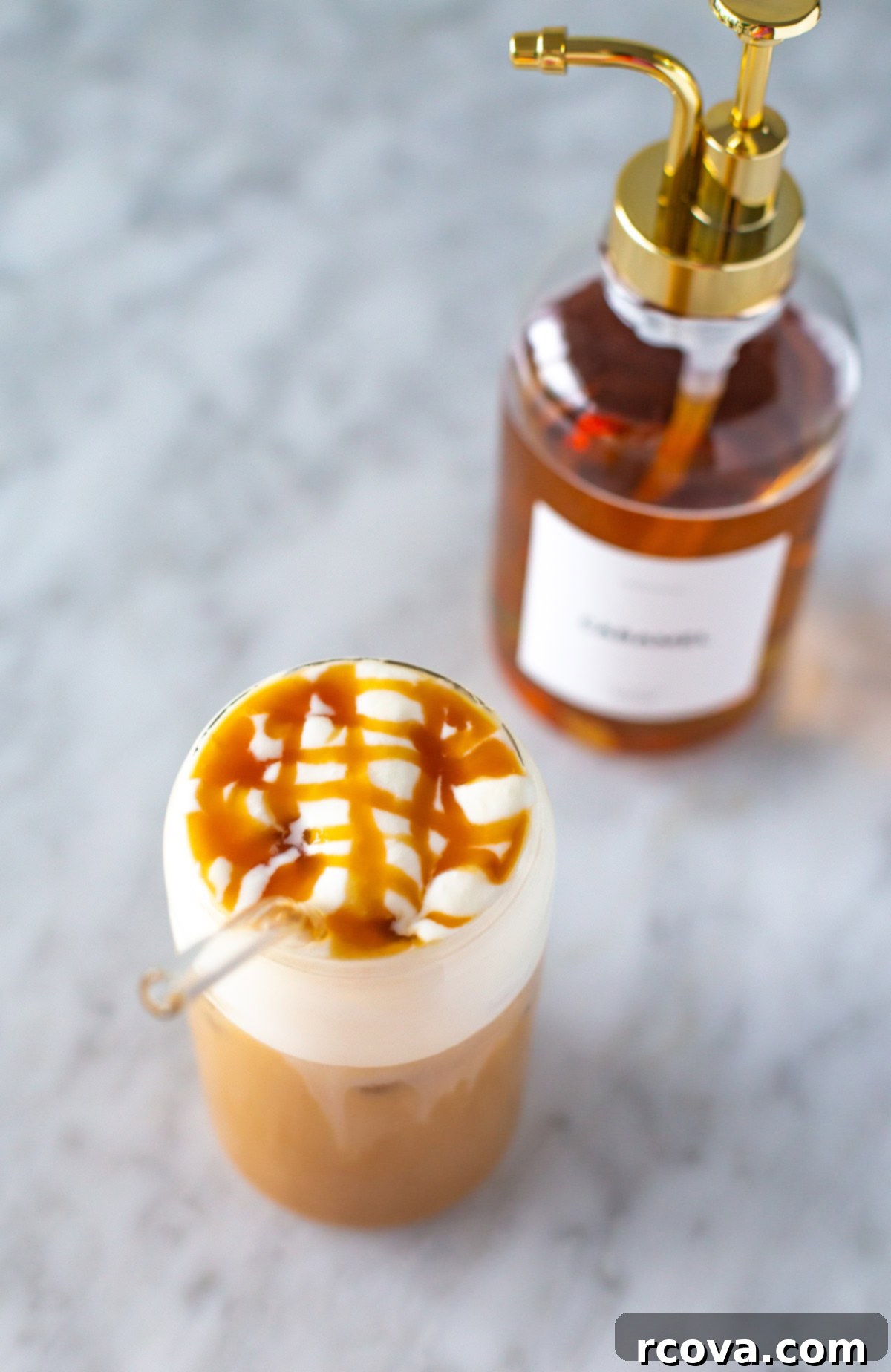 Barista Style Caramel Syrup for Iced Coffee 9 A jar of rich homemade caramel syrup positioned behind a beautifully prepared iced coffee, ready to be enjoyed.